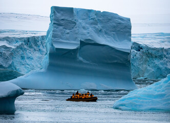 Boat full of tourists explore huge icebergs drifting in the bay near Ilulissat greenland arctic, Antarctic peninsula