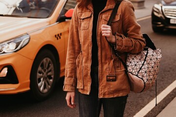 Young woman in stylish brown denim autumn fashionable jacket and black jeans. Street style casual...