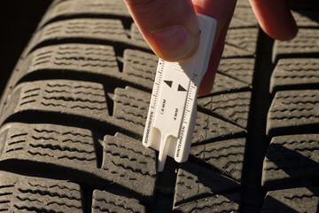 close-up of measuring tread depth of car tire