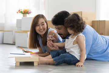 Moving house, mortgage, family and real estate concept. Happy family, father, mother and cute little daughter baby toddler girl playing and spending time together while moving into new house