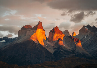 Torres Del Paine National Park, Chile. Patagonia. Mountains Cuernos, Sunrise at the Pehoe lake. Bright gold colors