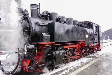 Fototapeta na wymiar an old fashioned steam engine is traveling down the train tracks