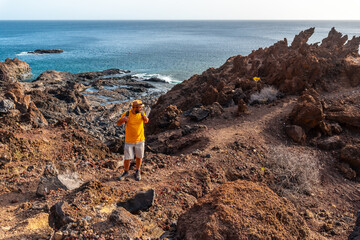 Tourist walking on a volcanic path on the beach of Tacoron on El Hierro, Canary Islands