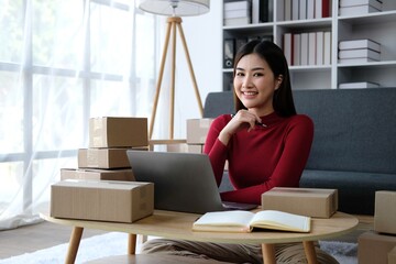 Startup small business entrepreneur of freelance Asian woman using a laptop with box Cheerful success online marketing packaging box and delivery SME idea concept