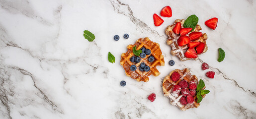 Berry Belgian Waffle with raspberries, strawberries and blueberries. Delicious sweet desert. Long banner format. top view