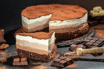 a piece of cake, three of chocolate on a dark background, place for text