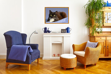 Custom-made home decoration concept: living room with a wing and a wicker chair and a square photo print of a black-and-white cat in a wooden frame.