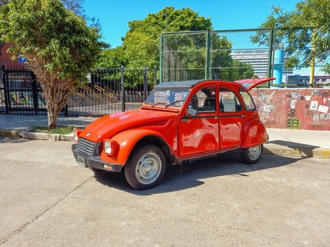 old red Citroen IES 3CV America 1986 parked in the street. Trees in th background. Classic car show