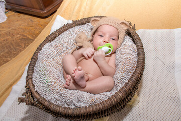 a newborn baby lies in a basket. baby with pacifier