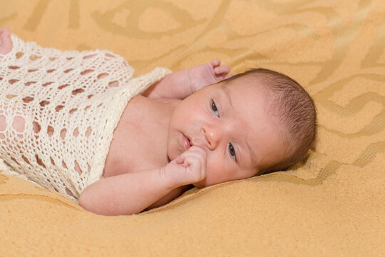 newborn child. little boy. newborn on a beige blanket. the first photo shoot. red baby
