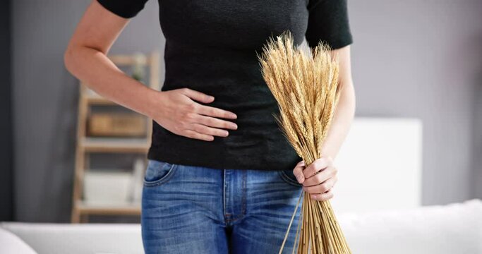 Celiac Disease And Gluten Intolerance. Women Holding Spikelet