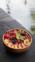 Healthy breakfast bowl: blueberry smoothie with banana dragon fruits, raspberry, blackberry, almonds, sunflower and chia seeds and granola