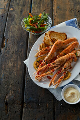Seafood with sauce and salad on table