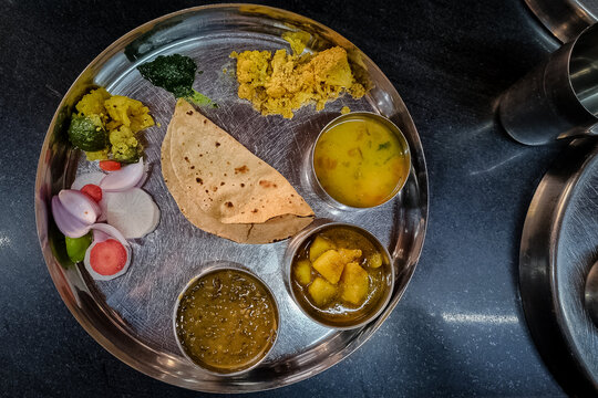 Close-up of Indian Vegetarian Thali with various dishes served in stainless steel bowl and plate.