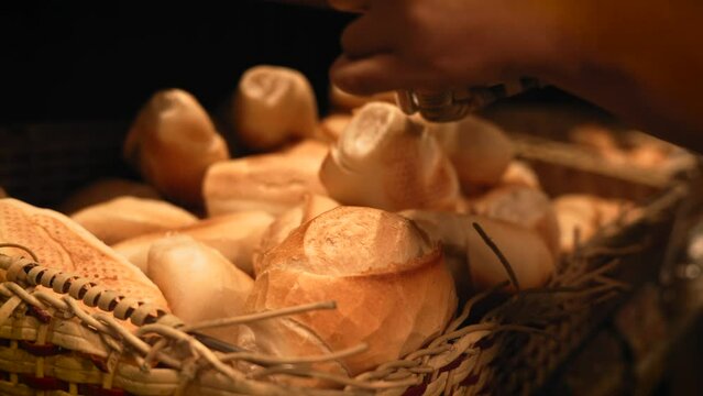 Man emptying fresh bread on a traditional bread basket