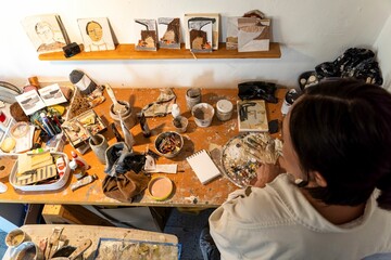 a woman at the artist table in front of her work