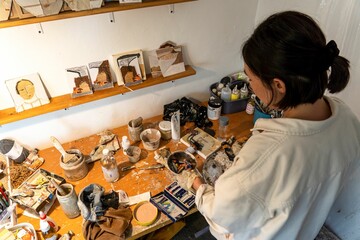 Female artist sitting at her desk, diligently working on her latest creative masterpiece