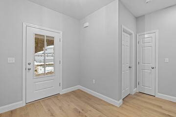 Modern, minimalist interior design featuring a white room with white doors, and wooden floor