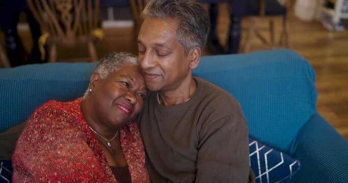 Smiling couple relaxing on sofa in living room