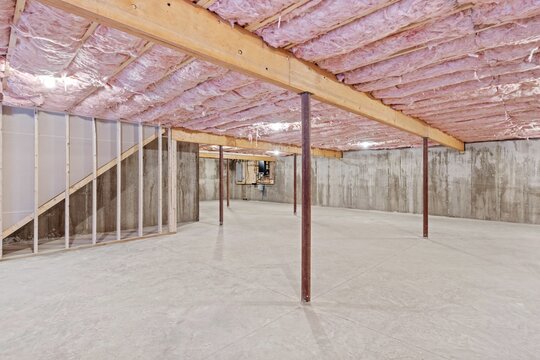 Unfinished home basement with the ceiling and concrete walls under construction