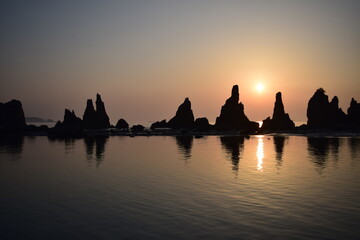 早朝の海岸に立つ奇岩