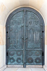 Ornate church door with relief of Archangelo-Mikhailovsky Zverinetsky monastery in Kyiv, Ukraine