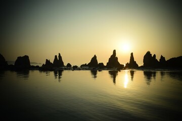 早朝の海岸に立つ奇岩