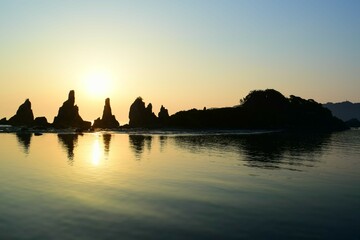 早朝の海岸に立つ奇岩