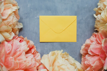Beautiful peonies and yellow envelope