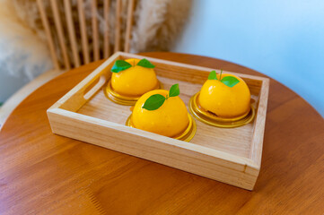 Round orange cake in a tray on a wooden table, Dessert,Obesity.