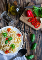Macaroni with cheese and vegetables. On a wooden background