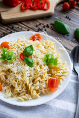 Macaroni with cheese and vegetables. On a wooden background