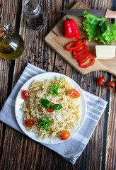Macaroni with cheese and vegetables. On a wooden background