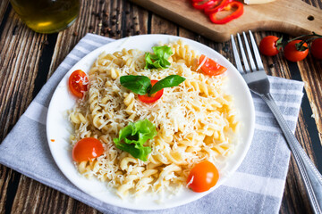 Macaroni with cheese and vegetables. On a wooden background