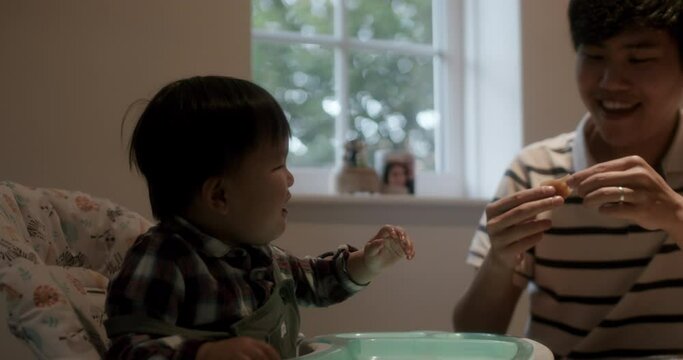 MS Father feeding baby son (18-23 months) at home