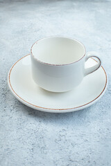 Close up shot of elegant empty white cup and sauce on isolated gray background with distressed surface