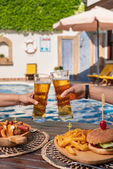 Eating at pool side. Cheers with beers