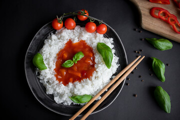 Rice with sweet and sour sauce. Dinner. On a black background