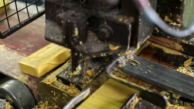 Close up of machine punching logo on soap bars in production line at factory