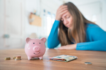 Woman with pink piggy bank is worried about money and household finances. Family savings economy