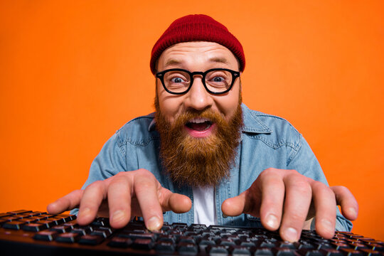 Portrait of excited young guy working on computer typing writing emails letters isolated on bright color background