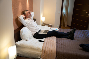Male resting in hotel room, finishing work