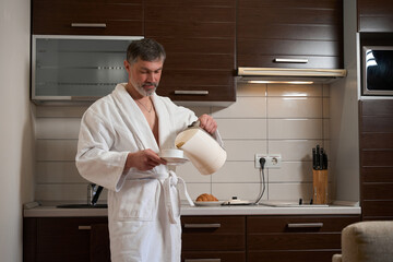 Male spending morning in hotel room, prepare drink
