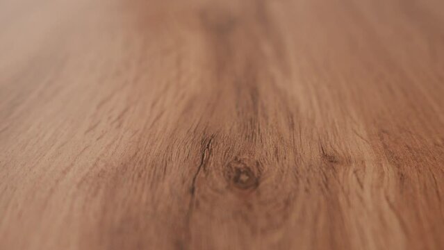 Close up texture of wooden table top with natural pattern. Part of the video is out of focus. 