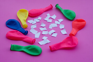 Colorful balloons and small pieces of paper on pink background. Concept Science project work...