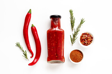 Red chili pepper sauce in bottle with ripe hot pepper