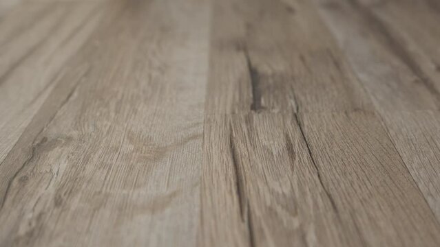 Close-up texture of light wooden parquet with natural pattern. Forward movement. Part of the subject is out of focus. High quality 4k footage