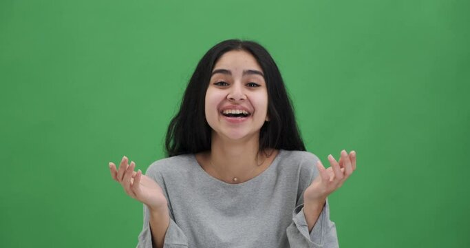 Portrait of beautiful young woman laughing over green chroma key background