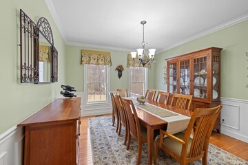 Spacious dining room with an abundance of wooden furniture and a striking green wall in the center