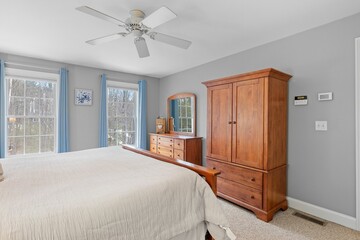 Cozy bedroom interior, furnished with a single bed, dresser, and large windows